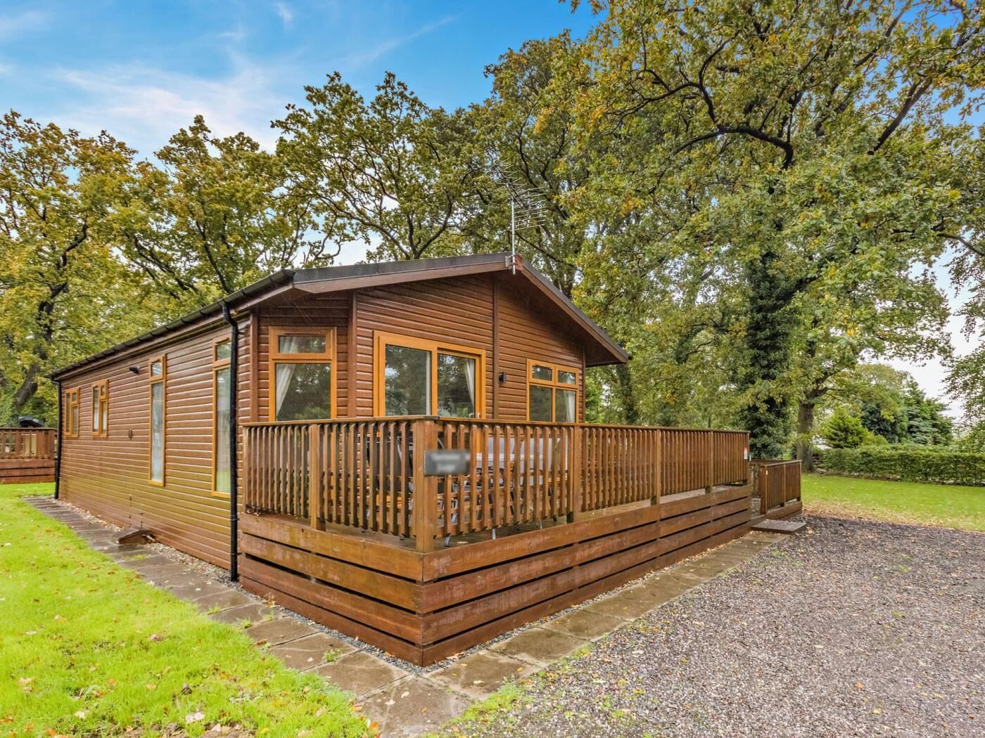 Une cabane en bois dotée d’un balcon, entourée d’arbres.