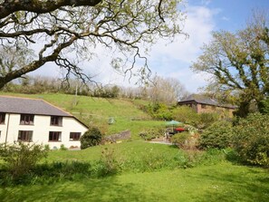 A rural setting with a white building, a stone structure, and a green umbrella. - 2 Bed in Ivybridge (oc-kemth) (Ugborough)