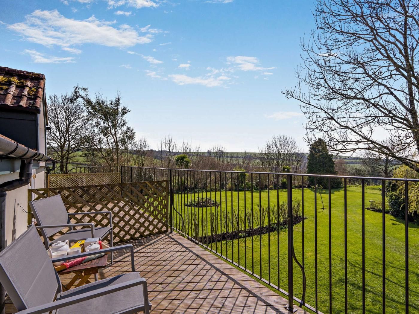 A patio area with outdoor furniture and a view of a well-maintained lawn and trees.