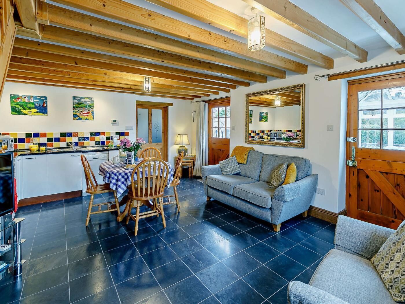 A cozy interior with a dining area, a sofa, and a kitchen.