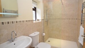 Ein Badezimmer mit Waschbecken, Toilette, Dusche und Spiegel.