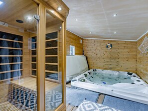 A sauna room with a wooden interior, a glass door, and a hot tub. - 4 Bed in Bideford (oc-nilga) (Bideford)