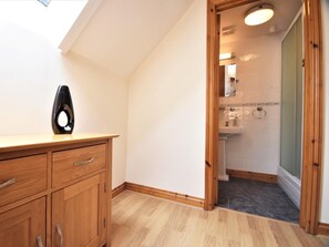 A modern bathroom with a shower, a toilet, and a sink. There is a wooden cabinet with drawers and a black vase on top. - 3 Bed in Umberleigh (oc-hbeer) (Warkleigh)