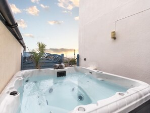 A hot tub with a view of a building and a palm tree in the background. - 5 Bed in Bideford (oc-09156) (Northam)