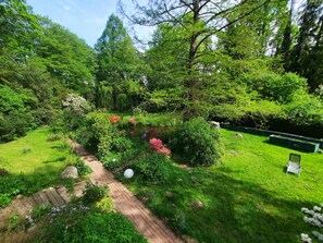 A garden with a paved path, lush greenery, and a small water feature. - Apartment in a half-timbered house with a unique garden. Golf Course, Steinhuder Meer. (Rehburg-Loccum)