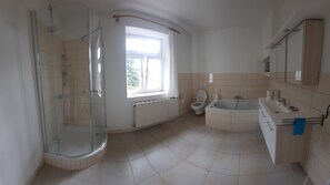 A bathroom with a glass-enclosed shower, a toilet, a bathtub, and a sink. - Apartment in a half-timbered house with a unique garden. Golf Course, Steinhuder Meer. (Rehburg-Loccum)