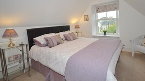 A bedroom with a bed, bedside lamps, a window with a view, and a chair. - 2 Bed in Huntly (oc-ab171) (Huntly)