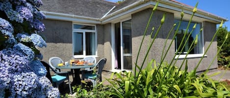 A house with a patio, a table with chairs, and a window.