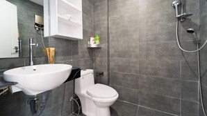 Un bagno moderno con lavandino, WC e doccia bianchi.