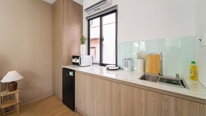 Una cucina moderna con lavastoviglie integrata, una finestra, un lavello e un piano di lavoro con una macchina da caffè e un tostapane.
