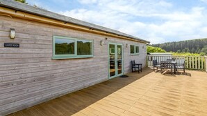 A wooden building with a sign reading 'GAMES ROOM,' a deck with outdoor furniture, and a scenic view. - 1 Bed in Ilfracombe (oc-parsc) (Berrynarbor)