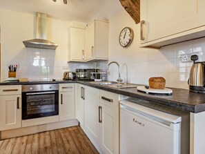 A kitchen with white cabinets, a stainless steel range hood, a microwave, a toaster, a sink, and a loaf of bread on the counter. - 1 Bed in Ilfracombe (oc-parsc) (Berrynarbor)
