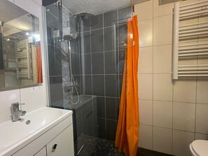 Ein Badezimmer mit Dusche, Waschbecken und Toilette.