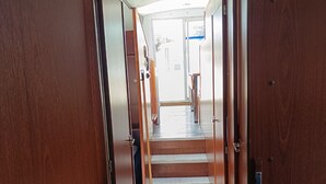 Ein Innenraum mit Holzwänden und einem Teppich zur Treppe, die zu einer Tür führt.