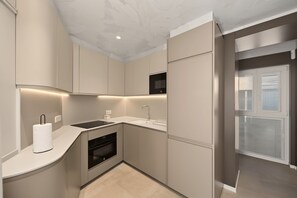 A compact kitchen with integrated appliances, a built-in oven, and a microwave. - Apartment 'Suite Plaza Conil' with Sea View, Wi-Fi and Air Conditioning (Conil de la Frontera)