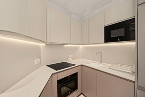 A modern kitchen with a built-in oven, a microwave, and a sink. - Apartment 'Suite Plaza Conil' with Sea View, Wi-Fi and Air Conditioning (Conil de la Frontera)