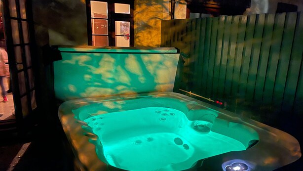 Ein Whirlpool mit Glasabdeckung, Bedienfeld und sichtbarem Wasserstand.