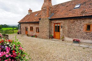 A stone building with a tiled roof, a wooden door, and windows. - 2 Bed in Taunton (oc-conco) (Monkton Heathfield)
