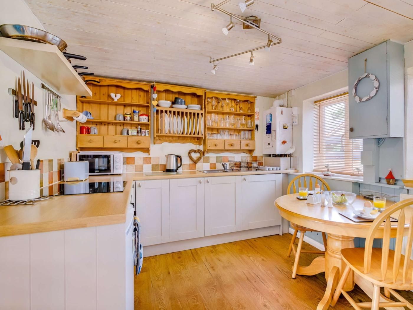 A kitchen with wooden cabinets, a central island, and a dining area with a table and chairs.