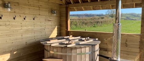Een houten sauna met banken en uitzicht op het landschap.