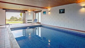 An indoor swimming pool with a tiled floor, wooden ceiling, and a bench. - 2 Bed in Holmfirth (oc-emley) (New Mill)