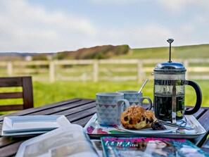A table with a coffee pot, two mugs, a plate with a pastry, and a magazine. - 2 Bed in Holmfirth (oc-emley) (New Mill)