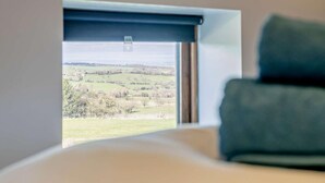 A room with a view of a rural landscape through a window with a blue blind. - 2 Bed in Holmfirth (oc-emley) (New Mill)