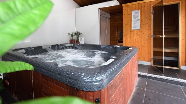A hot tub with a wooden interior, a wooden ceiling, and a tiled floor. - 10 Bed in Lampeter (oc-pontv) (Lampeter)