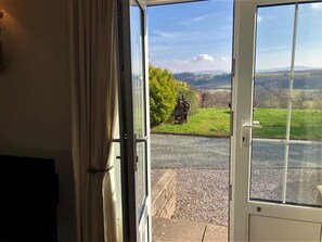 A door with a view of a gravel path, green grass, and distant hills. - 3 Bed in Conwy (oc-tygos) (Rowen)