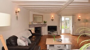 Ein Wohnzimmer mit Kamin, einer Couch, einem Fernseher und einem Couchtisch.