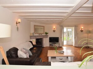 A living room with a fireplace, a sofa, a television, and a coffee table. - 3 Bed in Conwy (oc-tygos) (Rowen)