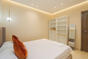 A bedroom with a bed, a hanging light fixture, a wardrobe, and a mirror. - TGV 7 min Corniche Plage WiFi fibre (Tanger)