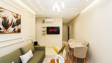 Căn hộ tiện nghi đơn giản | Khu phòng khách | Smart TV 50-inch có truyền hình cáp