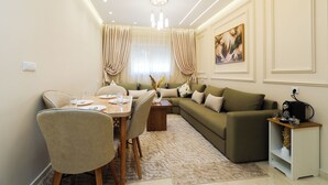 A modern living room with a dining area, a sofa, a coffee table, and a side table with a radio. - TGV 7 min Corniche Plage WiFi fibre (Tanger)