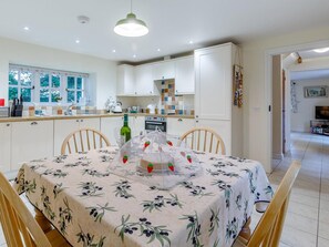 A dining area with a table set for four, surrounded by wooden chairs. - 2 Bed in Truro (oc-lrose) (Tregavethan)