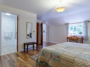 A bedroom with a large bed, a desk with a chair, a mirror, and a window with curtains. - 2 Bed in Truro (oc-lrose) (Tregavethan)