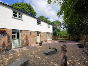A white building with stone accents, a gravel driveway, and a wooden fence. - 2 Bed in Truro (oc-lrose) (Tregavethan)