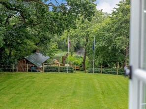 A grassy area with a wooden structure, a flagpole, and a pond. - 2 Bed in Truro (oc-lrose) (Tregavethan)