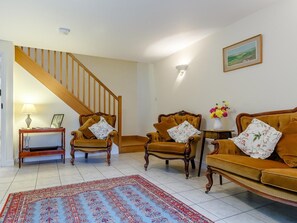A living room with a staircase, two armchairs, a sofa, a patterned rug, and a framed picture on the wall. - 2 Bed in Truro (oc-lrose) (Tregavethan)