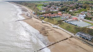 Een kustplaats met een strand, huizen en een ruim open gebied.