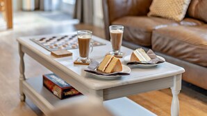 Ein Wohnzimmer mit Couchtisch, braunem Ledersofa und einem Fenster im Hintergrund.