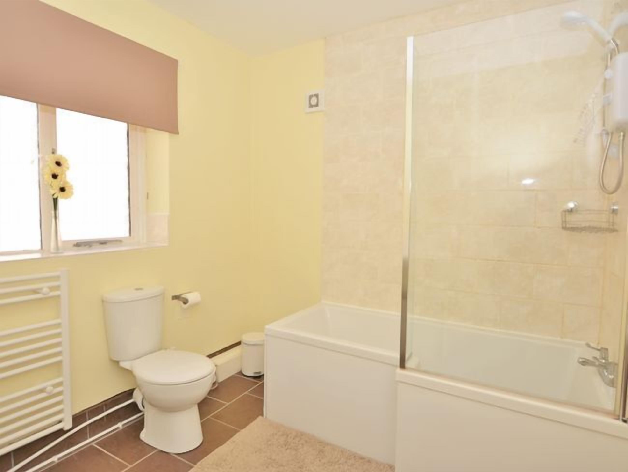 Une salle de bain avec des toilettes, une douche et une baignoire.