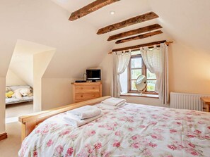 A bedroom with a bed, a dresser, a television, a window with curtains, and a radiator. - 4 Bed in Bridgnorth (oc-oship) (Shrewsbury)