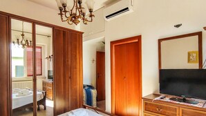 Ein Hotelzimmer mit einem Bett, einem Fernseher, einem Kleiderschrank und einem Spiegel.