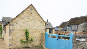 A stone building with a blue gate, a small tree, and a sign reading 'The Old Dairy.' - 1 Bed in Lechlade (oc-31912) (Lechlade)
