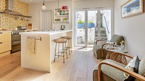 Una cucina moderna con isola centrale, pavimento in legno e un lucernario.