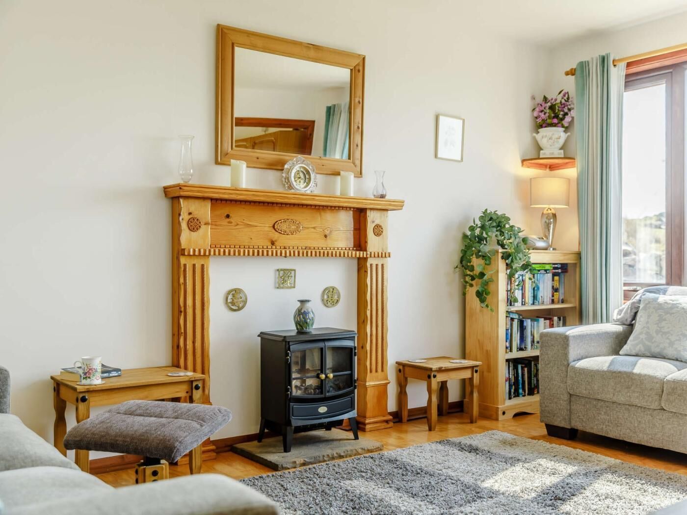A cozy living room with a fireplace, a sofa, a coffee table, and a bookshelf.