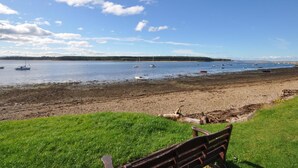 A beach with boats, a grassy area, and a bench. - 1 Bed in Forres (oc-32129) (Alves)