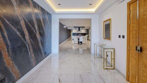 A hallway with a marble floor, a dark textured wall, and a wooden door. - Sliema 3BDR Flat with Seaview (Tas-Sliema)