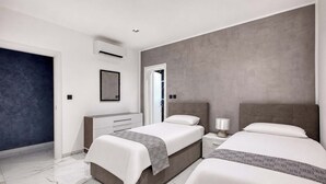 A modern hotel room with two beds, a large mirror, a wardrobe, and a bathroom door. - Sliema 3BDR Flat with Seaview (Tas-Sliema)